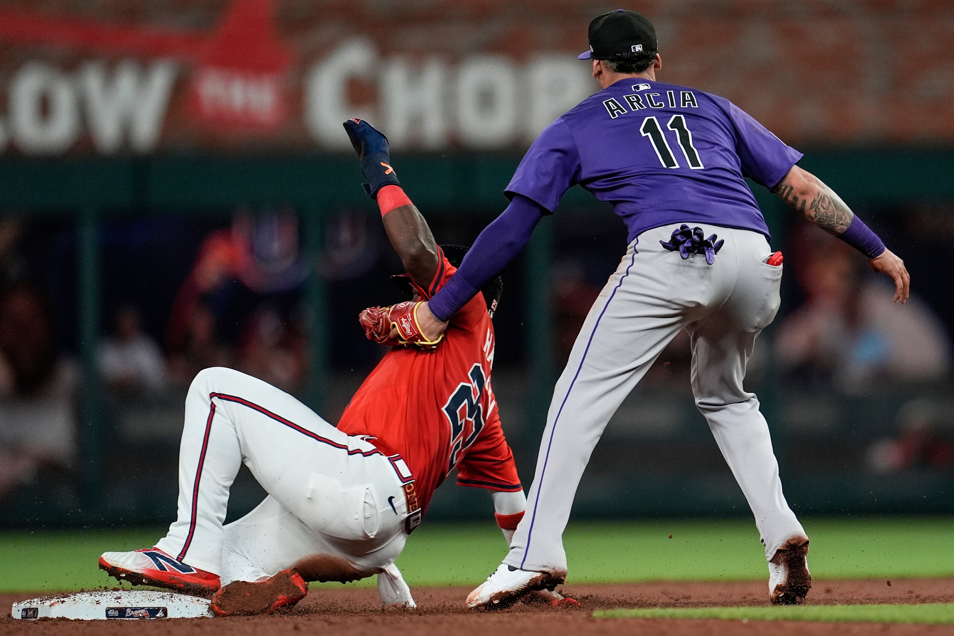 Colorado Rockies shortstop Orlando Arcia (11) tries to tag Braves center fielder Michael Harris II (23) with no ball during the eighth inning of Friday's game in Atlanta. (Mike Stewart/AP)