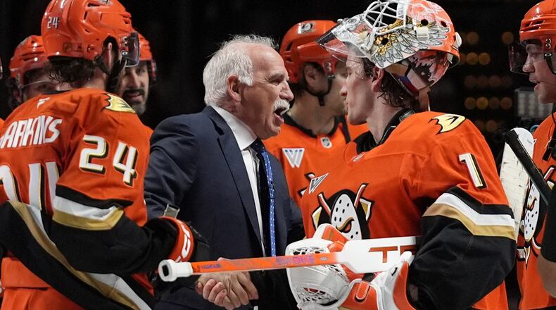 Anaheim Ducks head coach Joel Quenneville, center, celebrates with goaltender Lukas Dostal (1) after winning his 1,000th career coaching victory with a 6-4 win over the Edmonton Oilers in an NHL hockey game Wednesday, Feb. 25, 2026, in Anaheim, Calif. (AP Photo/Gregory Bull)