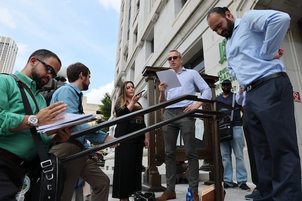 Sahib Arora, right, prepares to place a bid on the Peachtree Center office towers in September 2022 during a foreclosure auction at the Fulton County Courthouse. (Arvin Temkar/AJC)