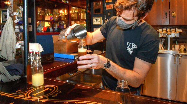 211220 Atlanta, Ga: Ticonderoga Club co-owner Paul Calvert mixes and fills bottles for to-go cocktails made to order from the walk-up window at the Club during a closure due to two staff members testing positive for COVID-19. (Chris Hunt for The Atlanta Journal-Constitution)
