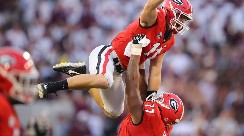 Georgia Bulldogs offensive tackle Isaiah Wynn hoists Georgia Bulldogs quarterback Jake Fromm in celebration on his touchdown pass on a flea flicker play to wide receiver Terry Godwin for a 7-0 lead over Mississippi State in a NCAA college football game on Saturday, Sept, 23, in Athens. Curtis Compton/ccompton@ajc.com