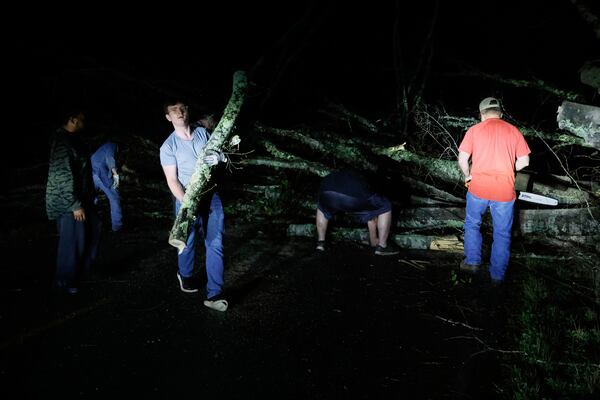 Locals help clear the roads from debris after a tornado passed through leaving a path of destruction, Saturday, March 15, 2025, in Plantersville, Ala. (AP Photo/Butch Dill)