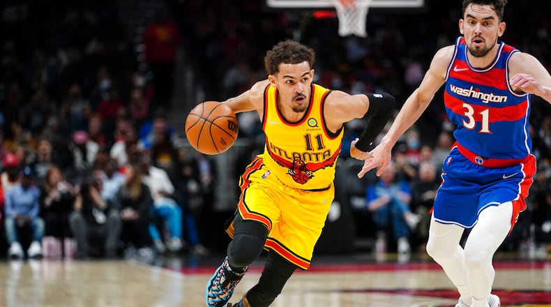 Atlanta Hawks' Trae Young (11) drives next to Washington Wizards' Tomas Satoransky (31) during the first half of an NBA basketball game Wednesday, April 6, 2022, in Atlanta. (AP Photo/John Bazemore)