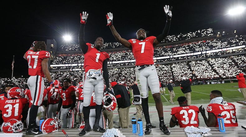 Georgia defensive backs Divaad Wilson (left) and Tyrique Stevenson signal the fourth quarter as fans light up Sanford Stadium during a 27-0 shut out over Missouri in a NCAA college football game on Nov. 9, 2019, in Athens. Curtis Compton/ccompton@ajc.com