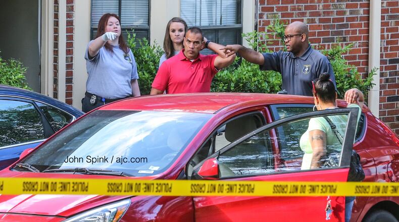 Gwinnett County police crime scene investigators work to collect evidence Friday morning after a man was shot at a townhouse on Patterson Circle. Multiple shell casings were found outside the residence, according to police.