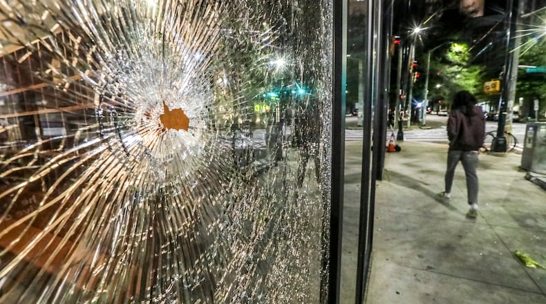 Shattered glass on the front of the Reflection Student Apartments located at 111 John Wesley Dobbs Ave. NE on April 3, 2023, was a remnant from the weekend's street racing and shootings. Several streets near Georgia State University's Atlanta campus were plagued with street racing and gunfire over the weekend. (John Spink / John.Spink@ajc.com)