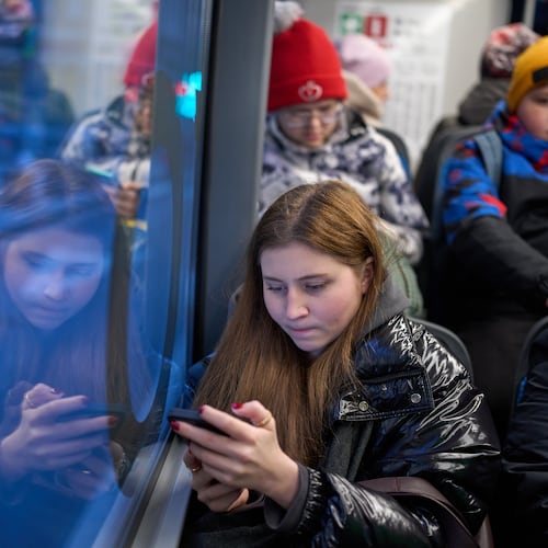 FILE - A woman looks at her smartphone on a bus in Moscow, Russia, Wednesday, Dec. 3, 2025. (AP Photo/Alexander Zemlianichenko, File)