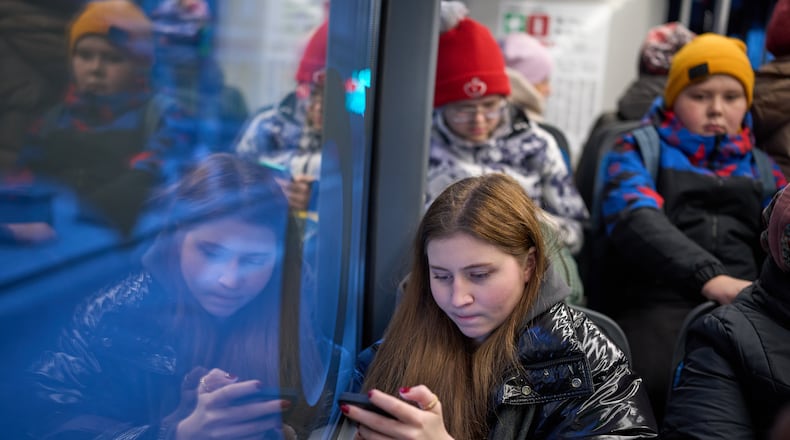 FILE - A woman looks at her smartphone on a bus in Moscow, Russia, Wednesday, Dec. 3, 2025. (AP Photo/Alexander Zemlianichenko, File)