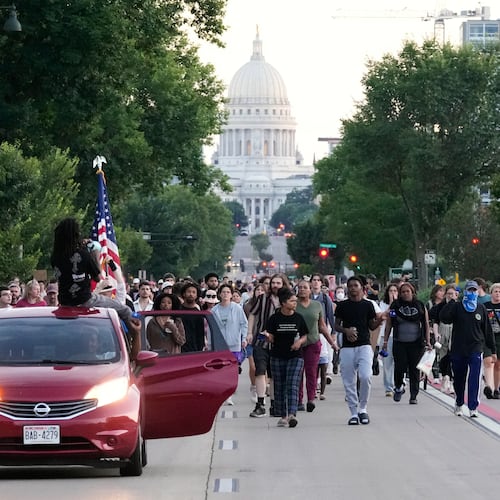Protesters march after a Madison police officer shot and killed a man Wednesday, July 22, 2026, in Madison, Wis. (AP Photo/Kayla Wolf)