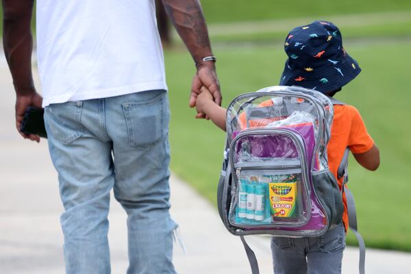 080322 Conley, Ga.: Father Gregory Samuel II holds the hand of his son Gregory Samuel III on the first day of school at Anderson Elementary School in August 2022. (Jason Getz / Jason.Getz@ajc.com)