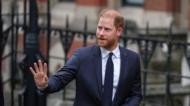 Britain's Prince Harry waves as he arrives at London's High Court to lead a group, including Elton John and Elizabeth Hurley, accusing the Daily Mail's publisher of privacy invasion through unlawful tactics in a trial that is part of a wider phone hacking scandal in London, Monday, Jan. 19, 2026. (AP Photo/Alastair Grant)