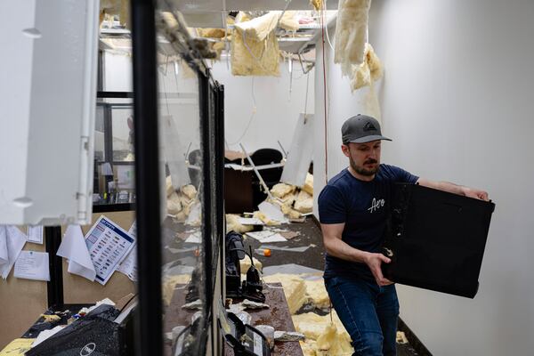 Daniel Fraser carries a computer in the damaged second floor offices of Specialty Distributors after a tornado passed through an industrial industrial park on Thursday, April 3, 2025, in Jeffersontown, Ky. (AP Photo/Jon Cherry)