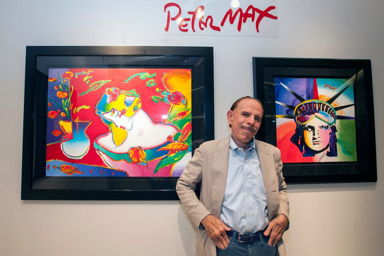 FILE - Artist Peter Max poses for a photo during his retrospective with the Road Show Company exhibit, Sept. 6, 2014, in Northbrook Court mall in Northbrook, Ill. (Photo by Barry Brecheisen/Invision/AP, File)