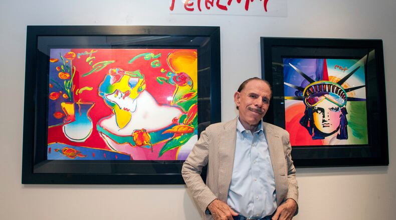 FILE - Artist Peter Max poses for a photo during his retrospective with the Road Show Company exhibit, Sept. 6, 2014, in Northbrook Court mall in Northbrook, Ill. (Photo by Barry Brecheisen/Invision/AP, File)