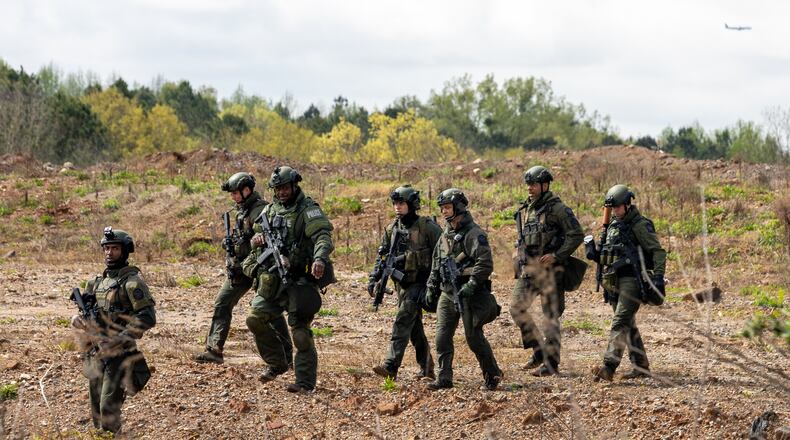 A police team walks through a land swap area near Intrenchment Creek Park in Atlanta on Monday, March 27, 2023. Agencies from across metro Atlanta, along with state agencies, were conducting a clearing operation of Intrenchment Creek Park led by DeKalb County Police. (i(Arvin Temkar / arvin.temkar@ajc.com)