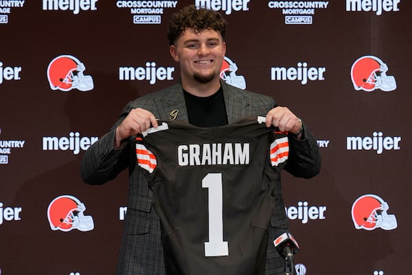 Cleveland Browns first-round draft pick, fifth overall, defensive tackle Mason Graham smiles as he poses for a photo with a jersey at an NFL football news conference in Berea, Ohio, Friday, April 25, 2025. (AP Photo/Sue Ogrocki)