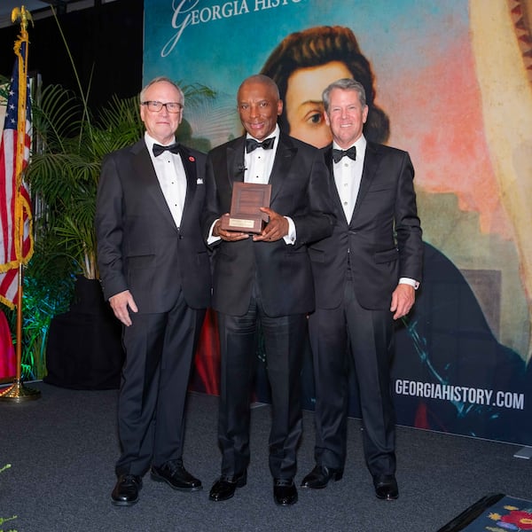 Dr. W. Todd Groce (left), president and CEO of the Georgia Historical Society and Gov. Brian Kemp (right) induct Chris Womack, chairman, CEO and president of Southern Co. as a 2026 Georgia Trustee on April 18, 2026, in Savannah. (Courtesy of Georgia Historical Society)