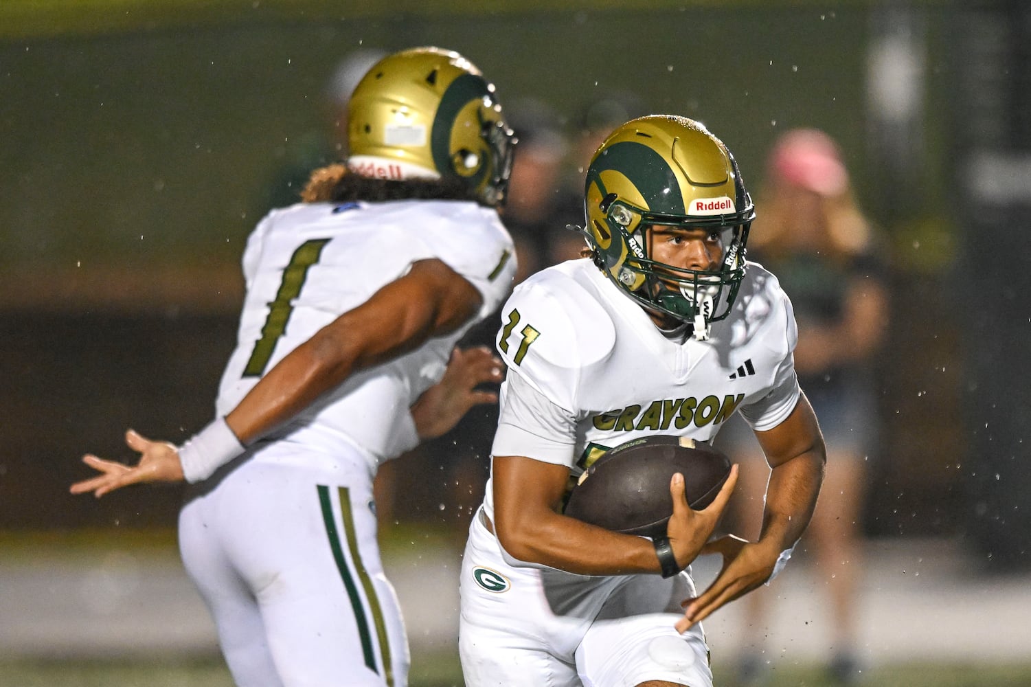 Grayson quarterback Travis Burgess hands off to running back Brandon Gray during the first half of play Friday, August 15, 2025. (Daniel Varnado for the AJC)