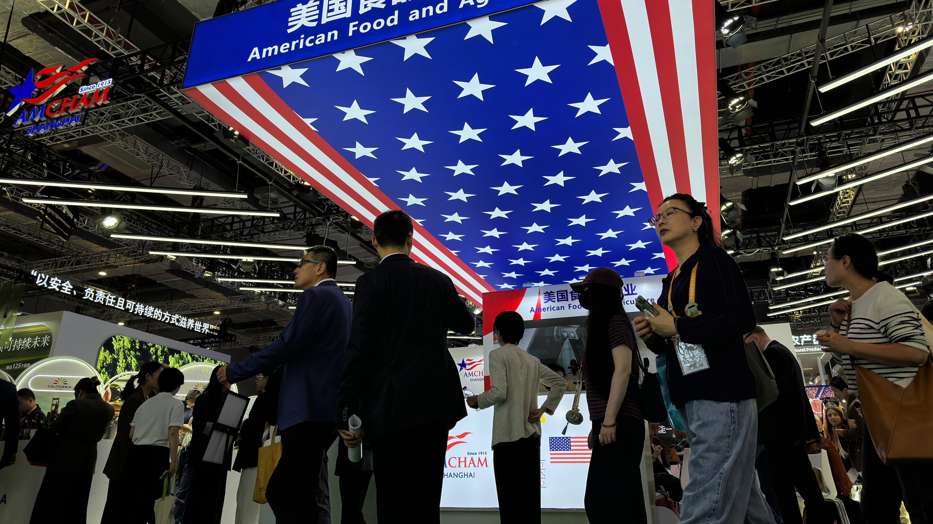 Visitors tour past the exhibition booth of American Food and Agriculture during the China International Import Expo, in Shanghai, China, Thursday, Nov. 6, 2025. (AP Photo/Wayne Zhang)