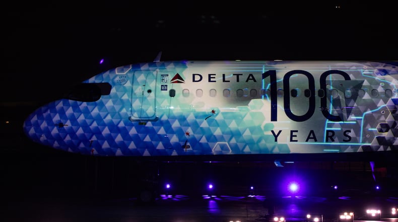 Delta Air Lines celebrates its 100 year anniversary on Saturday, March 15, 2025, at the Delta Flight Museum. The company unveiled a new airplane livery at the party and a light show was projected on the plane. (Jenni Girtman for The Atlanta Journal-Constitution)