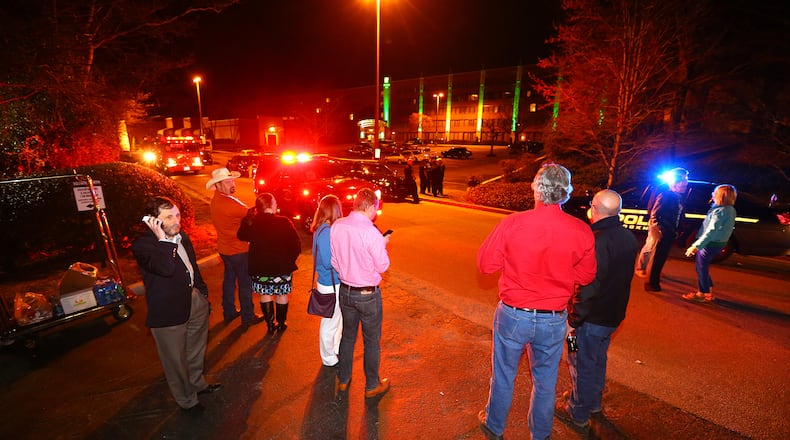 Evacuated guests wait in the street at the Holiday Inn on Chamblee Dunwoody Road while the DeKalb County bomb squad investigates a suspicious device on Thursday, March 20, 2014, in Atlanta. Four individuals have been taken into custody during an investigation into drug activity with narcotics, a weapon, and a suspicious device found on the scene. CURTIS COMPTON / CCOMPTON@AJC.COM