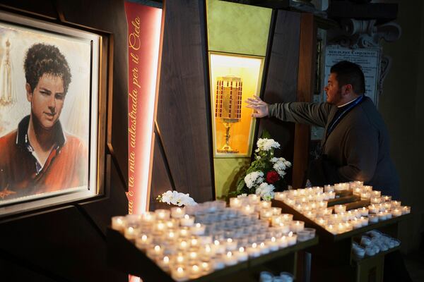 Rev. Cristopher Pujol prays at the heart relic of Carlo Acutis, the 15-year-old Italian boy who died in 2006 of leukemia and beatified in 2020, at the San Rufino Cathedral in Assisi, Italy, Wednesday, April 2, 2025. (AP Photo/Alessandra Tarantino)