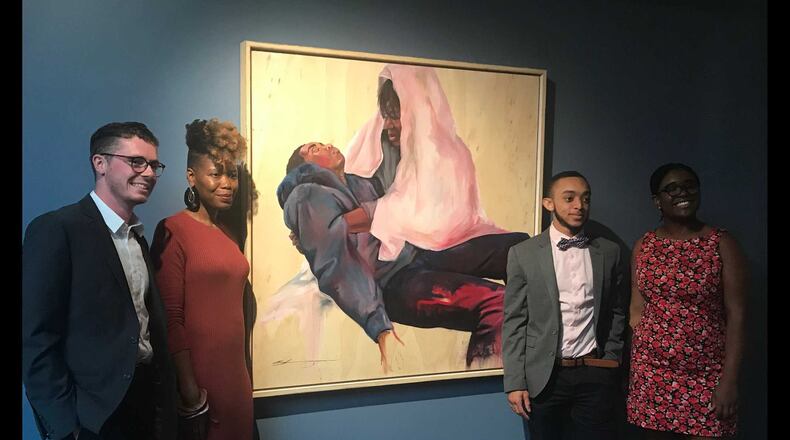 Oglethorpe University student leaders stand alongside artist Shanequa Gay, (second from left) whose work "La Pieta," is the first painting in the school's art museum by an African-American female artist. The students, Brad Firchow (left), Jordan Madison (second from right) and Taylor Roberts (right) used student government association funds to buy the piece in an effort to diversify the museum's collection. ERIC STIRGUS / ESTIRGUS@AJC.COM