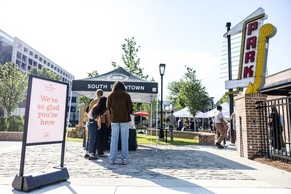 The entrepreneurs leading the transformation of several blocks of South Downtown held a ribbon cutting for their first green space on May 20. The sign to the left was excavated from the site.