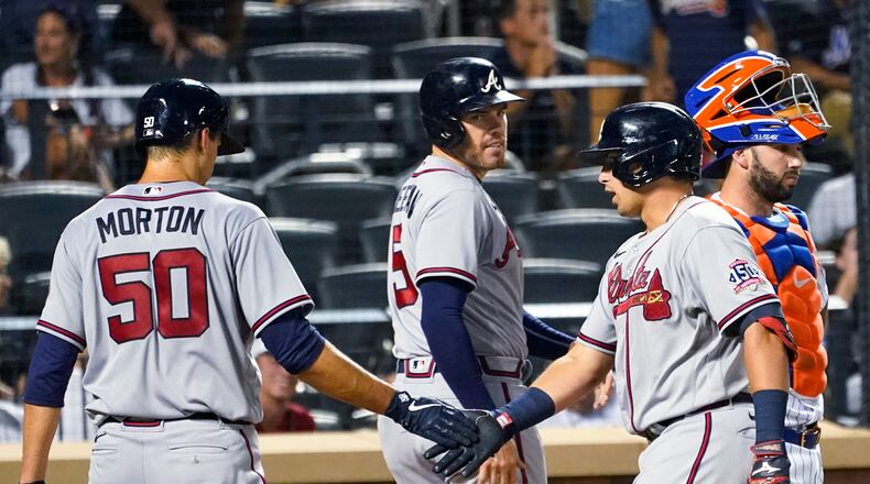 Atlanta Braves' Austin Riley, right front, celebrates with Charlie Morton (50) and Freddie Freeman (5) after they scored on Riley's grand slam during the fourth inning of the team's baseball game against the New York Mets, Tuesday, July 27, 2021, in New York. (AP Photo/Mary Altaffer)