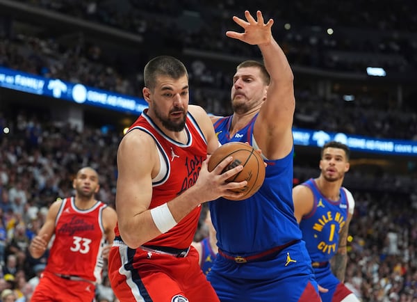 Los Angeles Clippers center Ivica Zubac, front left, pulls in a rebound as Denver Nuggets center Nikola Jokic, front right,defends in the second half of Game 7 of an NBA basketball first-round playoff series Saturday, May 3, 2025, in Denver. (AP Photo/David Zalubowski)