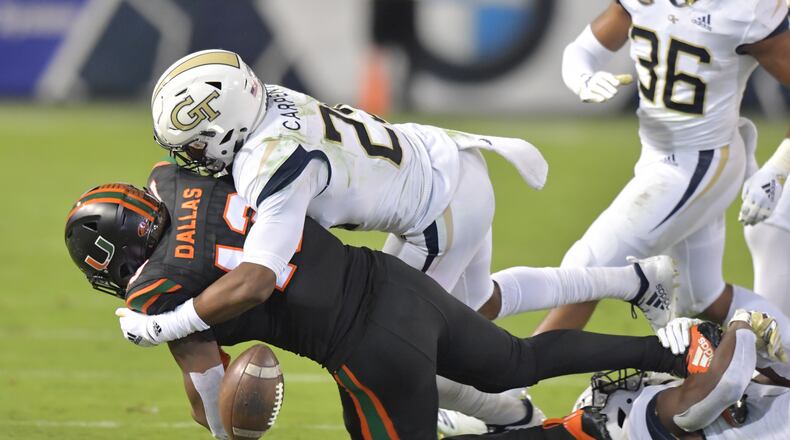 November 10, 2018 Atlanta - Miami running back DeeJay Dallas (13) gets tackled by Georgia Tech defensive back Tariq Carpenter (29) and Georgia Tech defensive back Charlie Thomas (45) causing a fumble later being picked up by Georgia Tech defensive back Ajani Kerr (38) in the first half at Bobby Dodd Stadium on Saturday, November 10, 2018. HYOSUB SHIN / HSHIN@AJC.COM