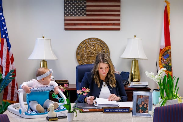 Florida Rep. Fiona McFarland, R-Sarasota, reviews a bill before committee as her 7-month-old daughter Grace Melton, left, watches, Thursday, April 17, 2025, in Tallahassee, Fla. (AP Photo/Colin Hackley)