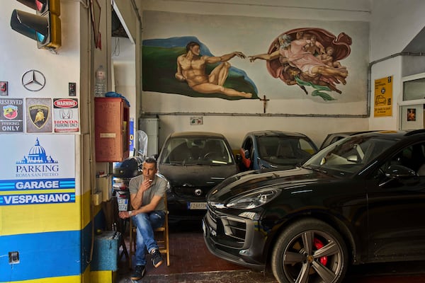 A reproduction of Michelangelo's "The Creation of Adam" is painted on a parking in Rome, Tuesday, May 6, 2025. (AP Photo/Bernat Armangue)