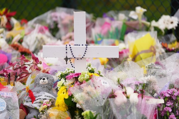 A cross stands at a memorial for victims after a vehicle drove into a crowd during a Filipino heritage festival in Vancouver, British Columbia, Monday, April 28, 2025. (AP Photo/Lindsey Wasson)