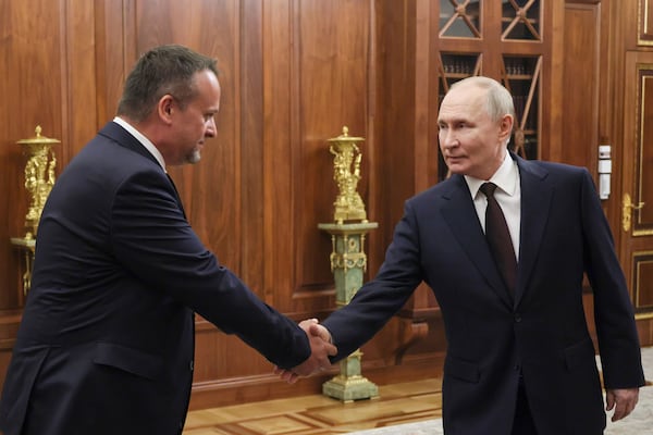Russian President Vladimir Putin, right, shakes hands with a newly appointed acting Transport Minister Andrey Nikitin during their meeting at the Kremlin in Moscow, Russia, Monday, July 7, 2025. (Mikhail Metzel, Sputnik, Kremlin Pool Photo via AP)