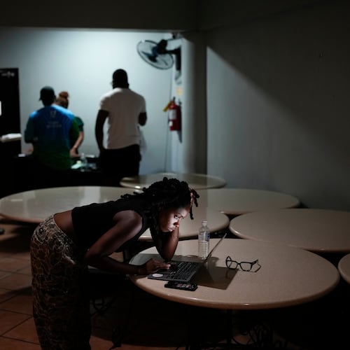 A woman video chats with a friend ahead of Hurricane Melissa's forecast arrival in Kingston, Jamaica, Monday, Oct. 27, 2025. (AP Photo/Matias Delacroix)