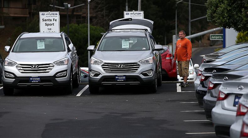 A customer looks at a brand new Hyundai Santa Fe mid-size crossover vehicle at Hyundai Serramonte in Colma, California.
