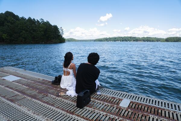 Jasmine Ferriola, 18, and Mavis Sanchez, 19, talk on the dock on Lake Lanier in Mountain View Park in Gainesville, Georgia, on Wednesday, July 2, 2025. Sanchez said they needed somewhere to cool off on the hot day. (Abbey Cutrer / AJC)