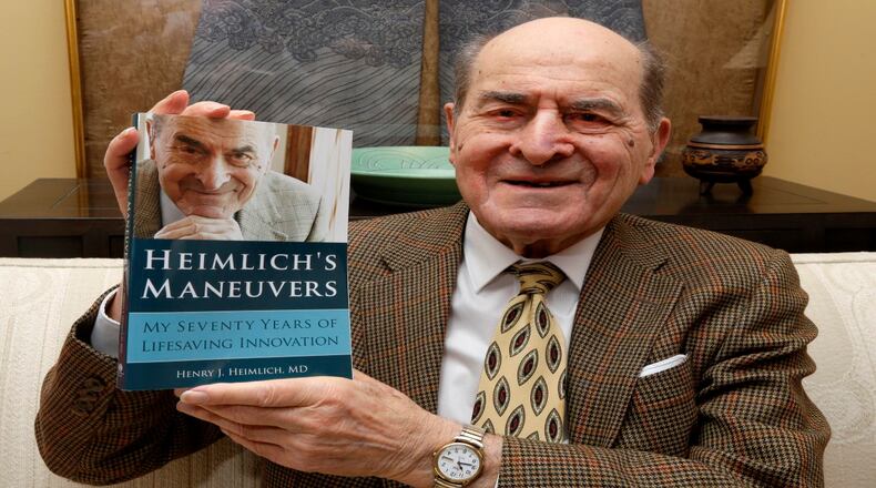 In this Wednesday, Feb. 5, 2014 photo, Dr. Henry Heimlich holds his memoirs prior to being interviewed at his home in Cincinnati. Heimlich is known for developing the Heimlich maneuver that has been used to clear obstructions from the windpipes of choking victims around the world for four decades. (AP Photo/Al Behrman)