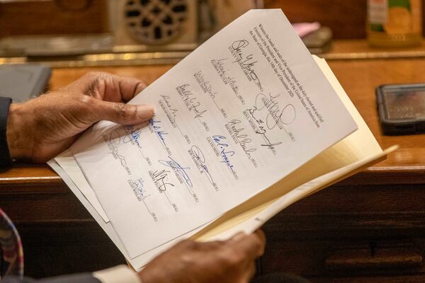 A member of the Georgia Electoral College looks over a Certificate of Vote during the official casting of the ballot in the Georgia Senate Chambers at the Georgia State Capitol building in Atlanta, Monday, December 14, 2020.  (Alyssa Pointer / Alyssa.Pointer@ajc.com)