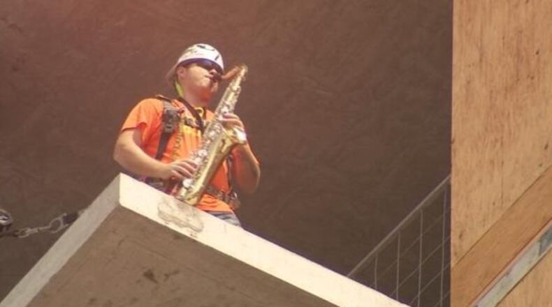 A construction worker is playing the saxophone to raise awareness and save a music venue. (Photo: KIRO7.com)