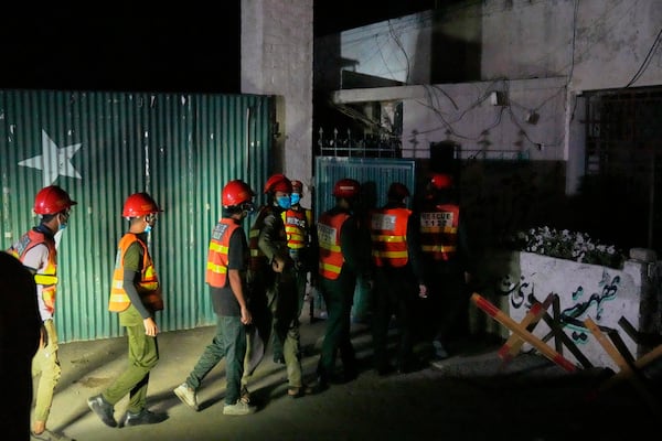 Rescue workers enter a building near the site of a suspected Indian missile attack, in Muridke, a town in Pakistan's Punjab province, Wednesday, May 7, 2025. (AP Photo/K.M. Chaudary)