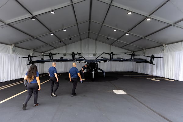 A group of Southern Company employees views Archer’s Midnight electric vertical take-off and landing (eVTOL) aircraft at DeKalb-Peachtree Airport in Atlanta. Archer Aviation is one of many Georgia based aerospace industry firms. (Arvin Temkar/AJC 2024)