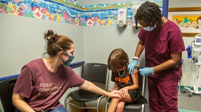 Sofia Rosenthal is shown here receiving her COVID-19 vaccination on Monday, her 12th birthday, from Phoena Mack at Dekalb Pediatrics in Decatur.  As a newly minted 12-year-old it was the first day Rosenthal was eligible.  Her mother, Kristen Rosenthal, sat next to her to comfort her, as Sofia was not looking forward to the shot.  But Sofia left proud of herself, said Dr. Jane Wilkov.   (PHOTO by STEVE SCHAEFER FOR THE ATLANTA JOURNAL-CONSTITUTION)