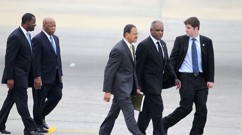 Then-Atlanta Mayor Kasim Reed, Rep. John Lewis, Rep. Sanford Bishop, Rep. David Scott, and an unidentified person walk on the runway at Dobbins Air Reserve base to meet President Barack Obama in 2010. Bob Andres bandres@ajc.com