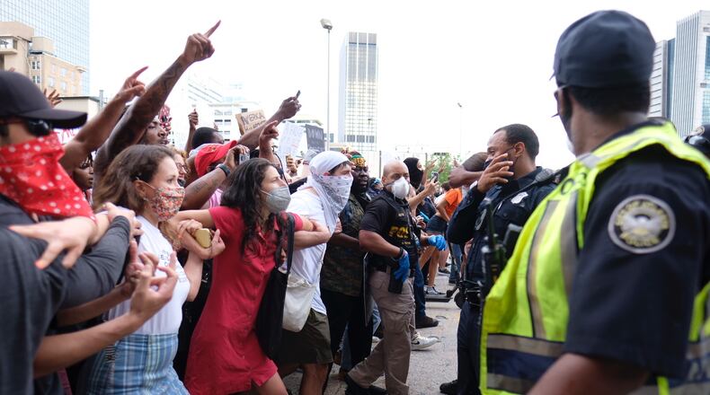 May 29, 2020 - Atlanta - After a peaceful march the Georgia State Capitol that swelled into the hundreds, protestors returned to the area around the Centennial Olympic Park and CNN center where some confronted police, who sprayed some demonstrators with pepper spray. They carried signs and chanted their messages of outrage over the death of George Floyd in Minneapolis. Ben Gray for the Atlanta Journal Constitution