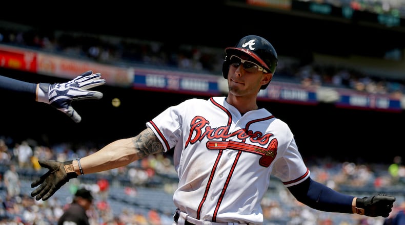Atlanta Braves' Jordan Schafer high-fives teammate Freddie Freeman, left, after scoring off a single by Jason Heyward in the first inning of a baseball game against the Minnesota Twins, Wednesday, May 22, 2013, in Atlanta. (AP Photo/David Goldman)