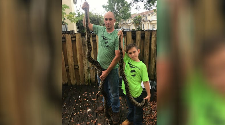 Eight-year-old Joe Daskam (left) caught a 6-foot python in the Florida everglades and his father, Steve Daskam, caught an 8-foot-long snake.