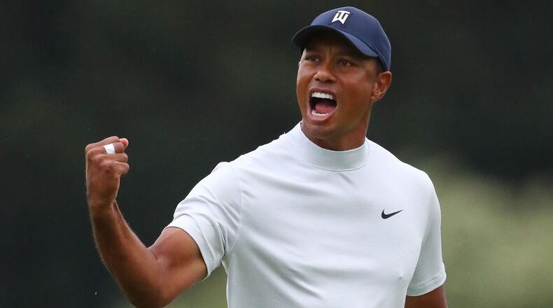 Tiger Woods lets out a roar after his birdie putt on 15 Friday. (Curtis Compton / ccompton@ajc.com)