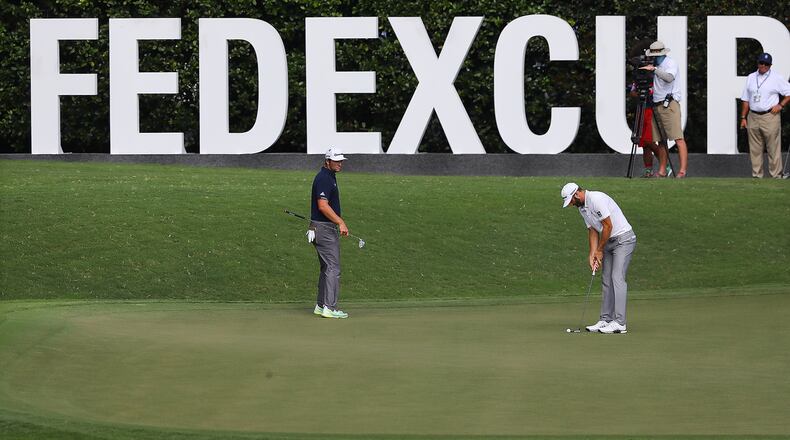 Dustin Johnson (right) and Jon Rahm (left) putt on the 11th green during the second round of the Tour Championship Saturday, Sept. 2, 2020, at East Lake Golf Club in Atlanta. (Curtis Compton / Curtis.Compton@ajc.com)